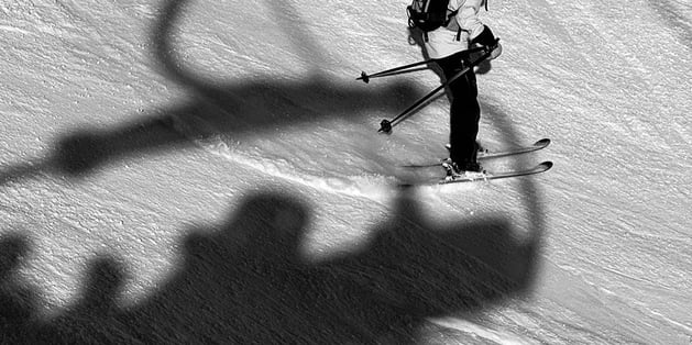 Skier with shadow of ski lift on them