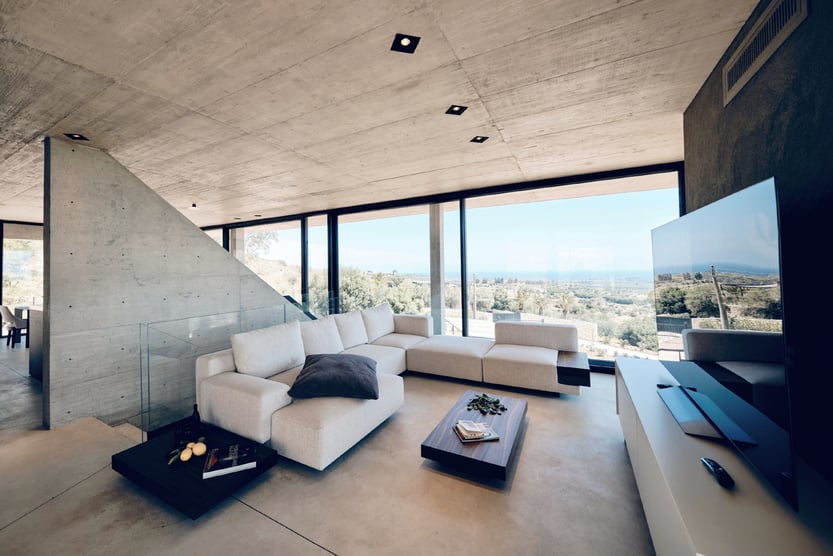living room at casa di cemento with white furniture and concrete walls, floor, and ceiling.