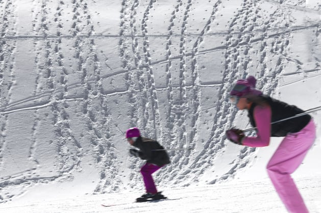 Two skiiers going by in a blur