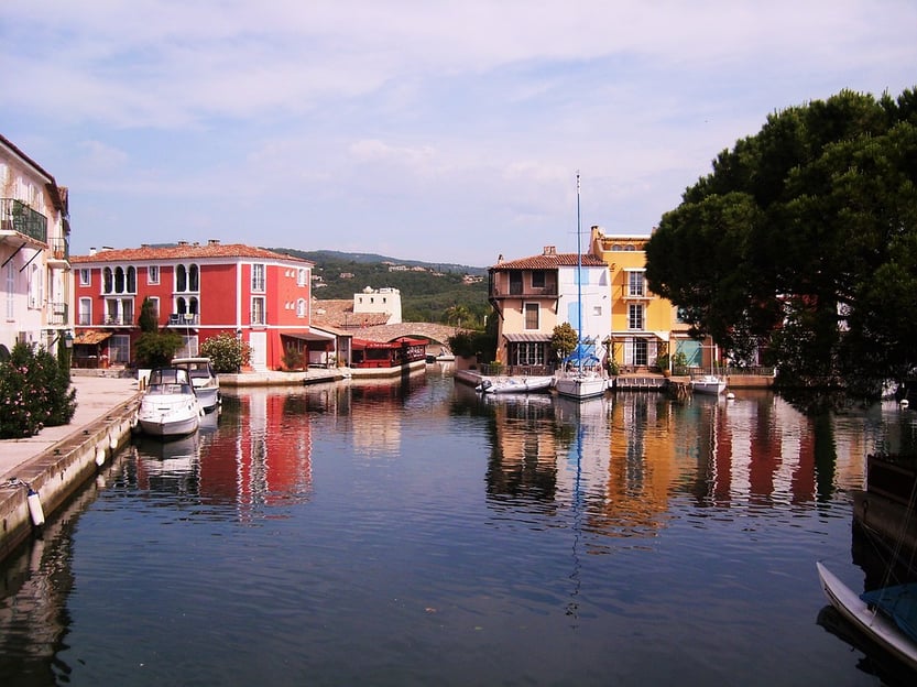 vue-depuis-le-port-grimaud-canal-rempli-de-petits-bateaux-entoure-d-arbres-et-de-maisons-colores-village-de-pecheur-traditionnel-saint-tropez