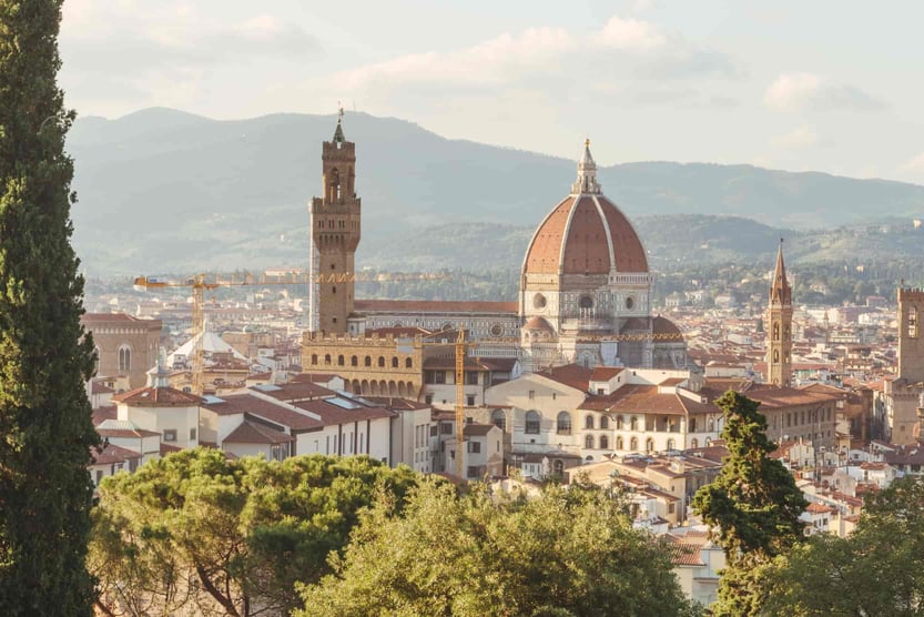 Florence-cityscape-with-domed-roofs-and-clusters-of-terracotta-roofs-with-trees-in-the-foreground