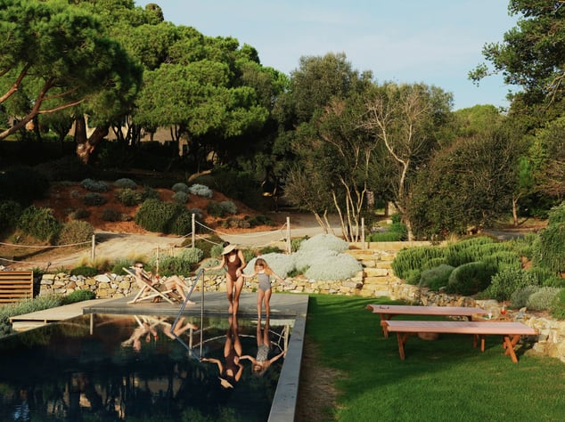 family enjoying a private pool at their secluded villa surrounded by nature