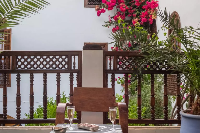 balcon-avec-plantes-une-chaise-deux-verres-de-vin-riad-marrakech-min