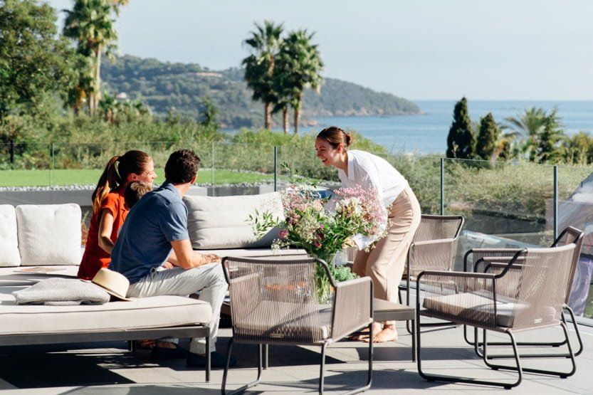 le collectionist team member meeting with a family on the terrace of their villa
