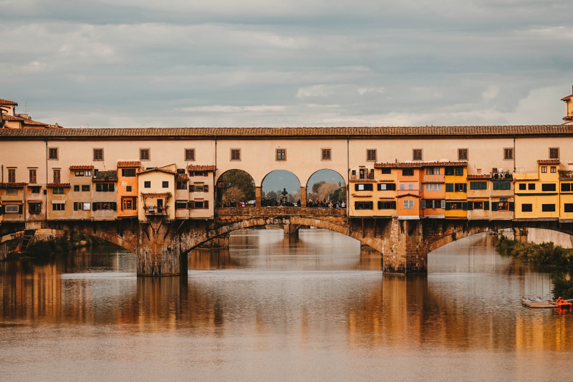 pont-avec-des-maisons-typiques-roses-jaunes-et-oranges-surplombant-un-fleuve-a-florence