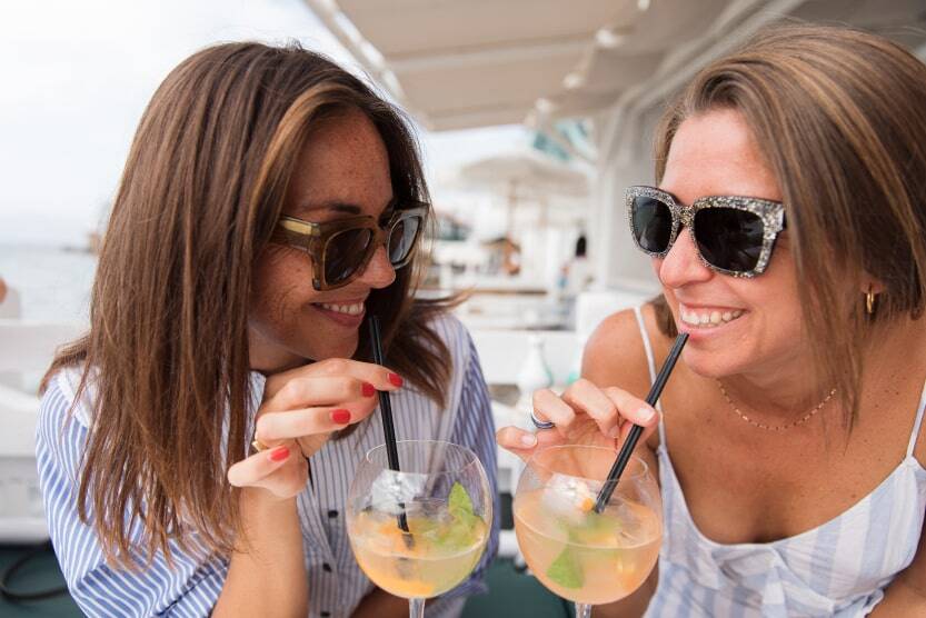 greek holidays best things to do in mykonos town girls drinking cocktails by the beach