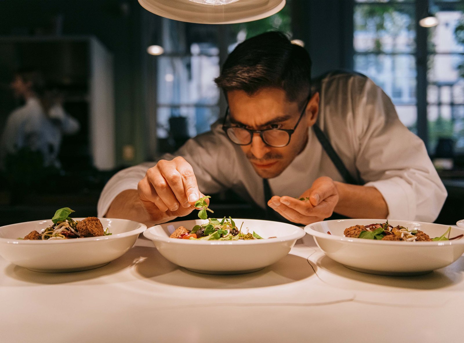 Chef dressant des assiettes dans la cuisine d’un restaurant gastronomique
