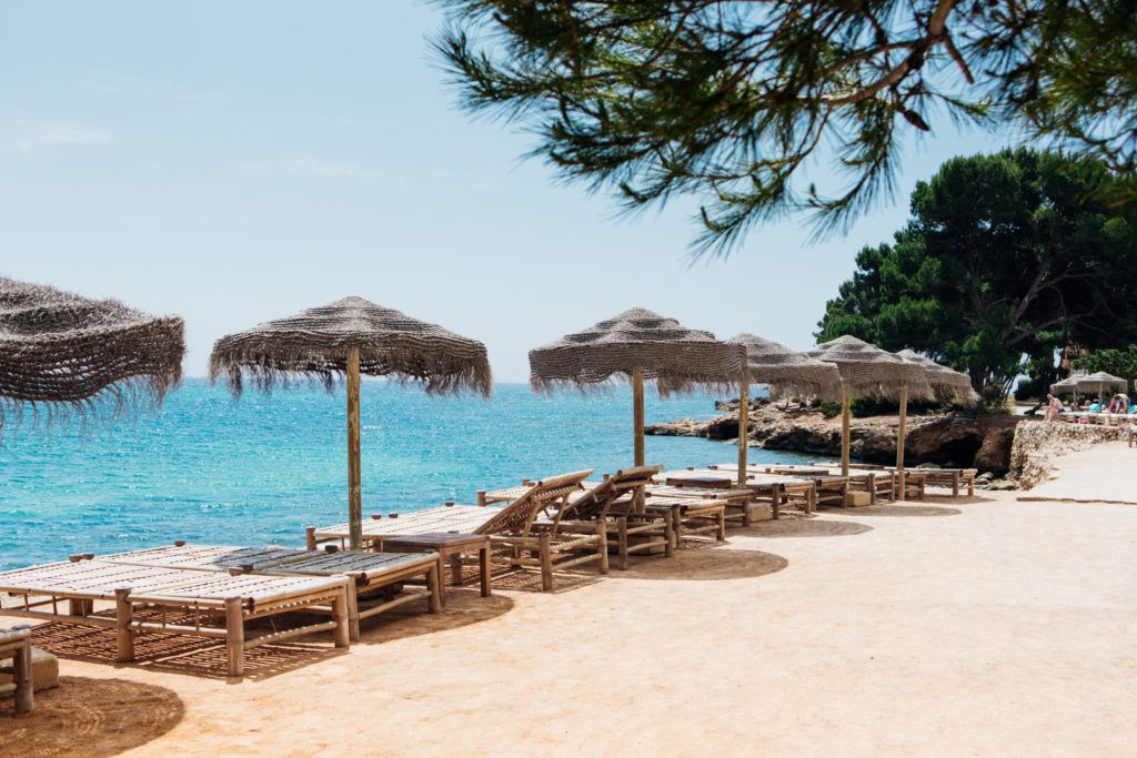 club-de-plage-desert-sur-le-sable-avec-transats-et-parasols-face-a-la-mer-a-ibiza-en-septembre