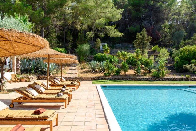 poolside and lounge chairs outside villa in ibiza