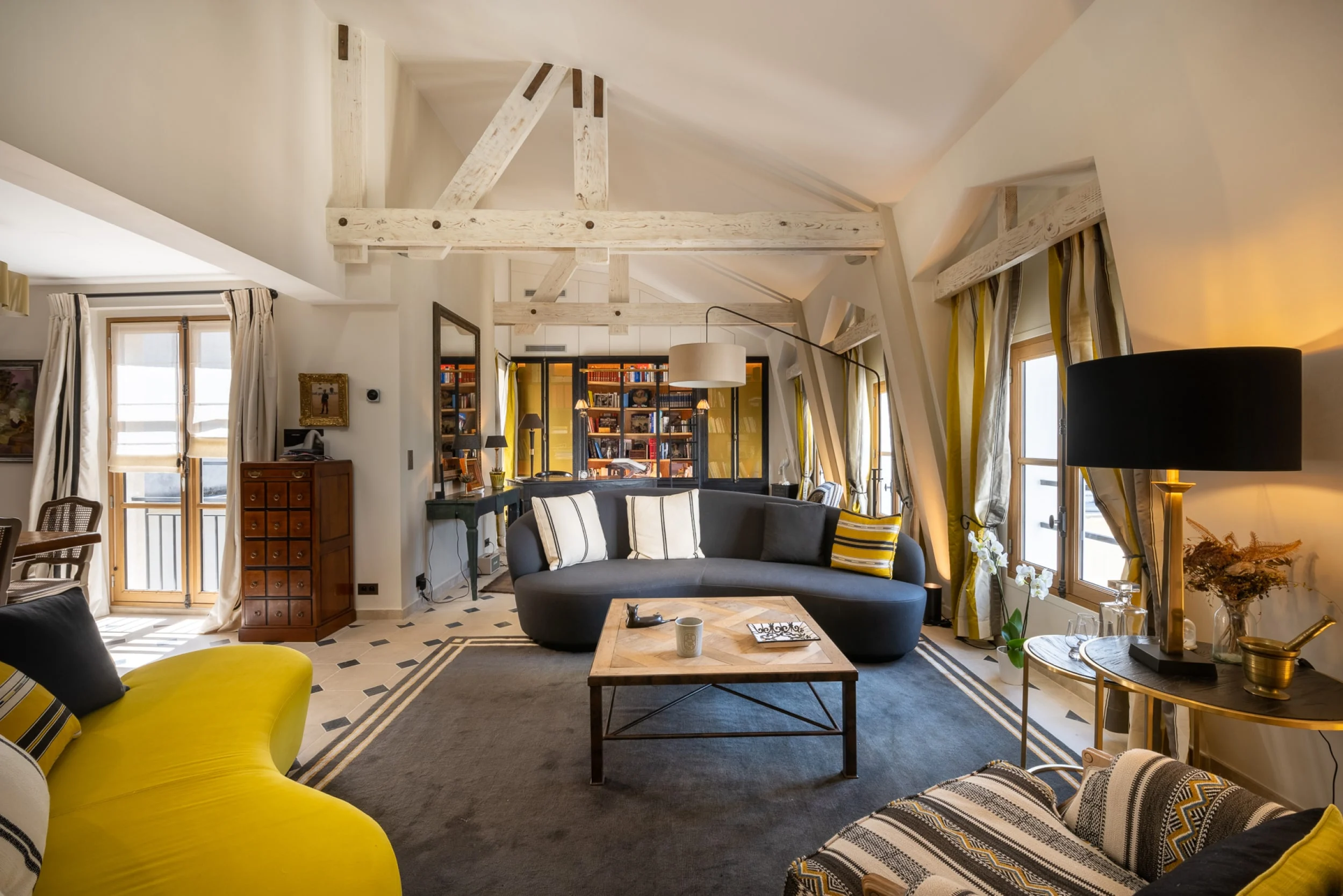 salon-avec-poutre-apparente-et-a-la-decoration-vintage-du-penthouse-saint-germain-a-paris