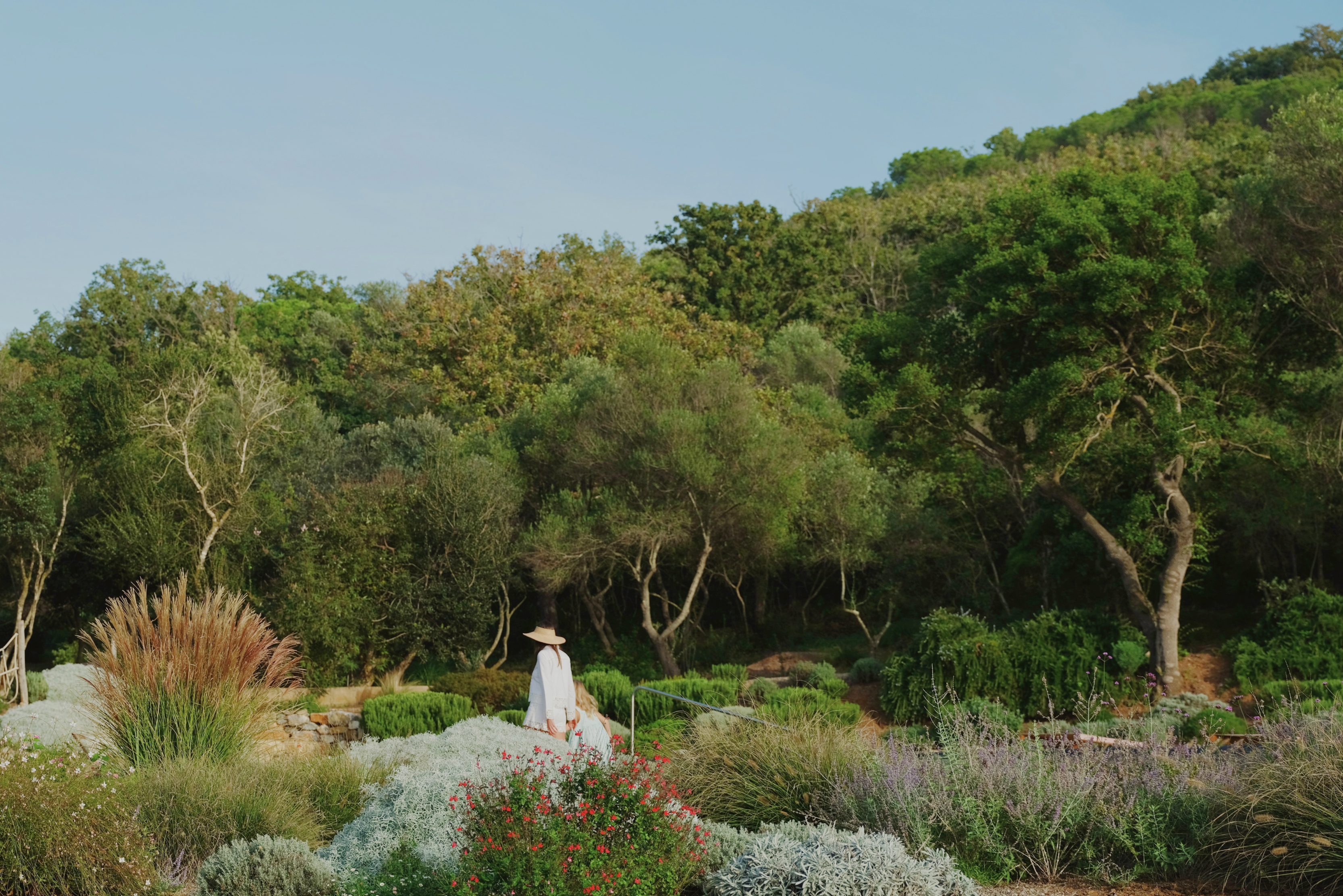 mother and daughter walking amongst greenery