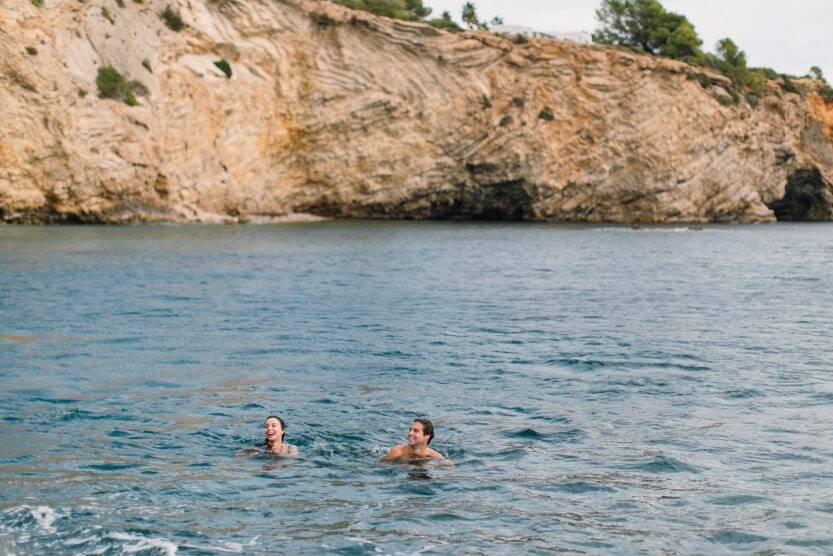 man and woman swimming in cove in ibiza