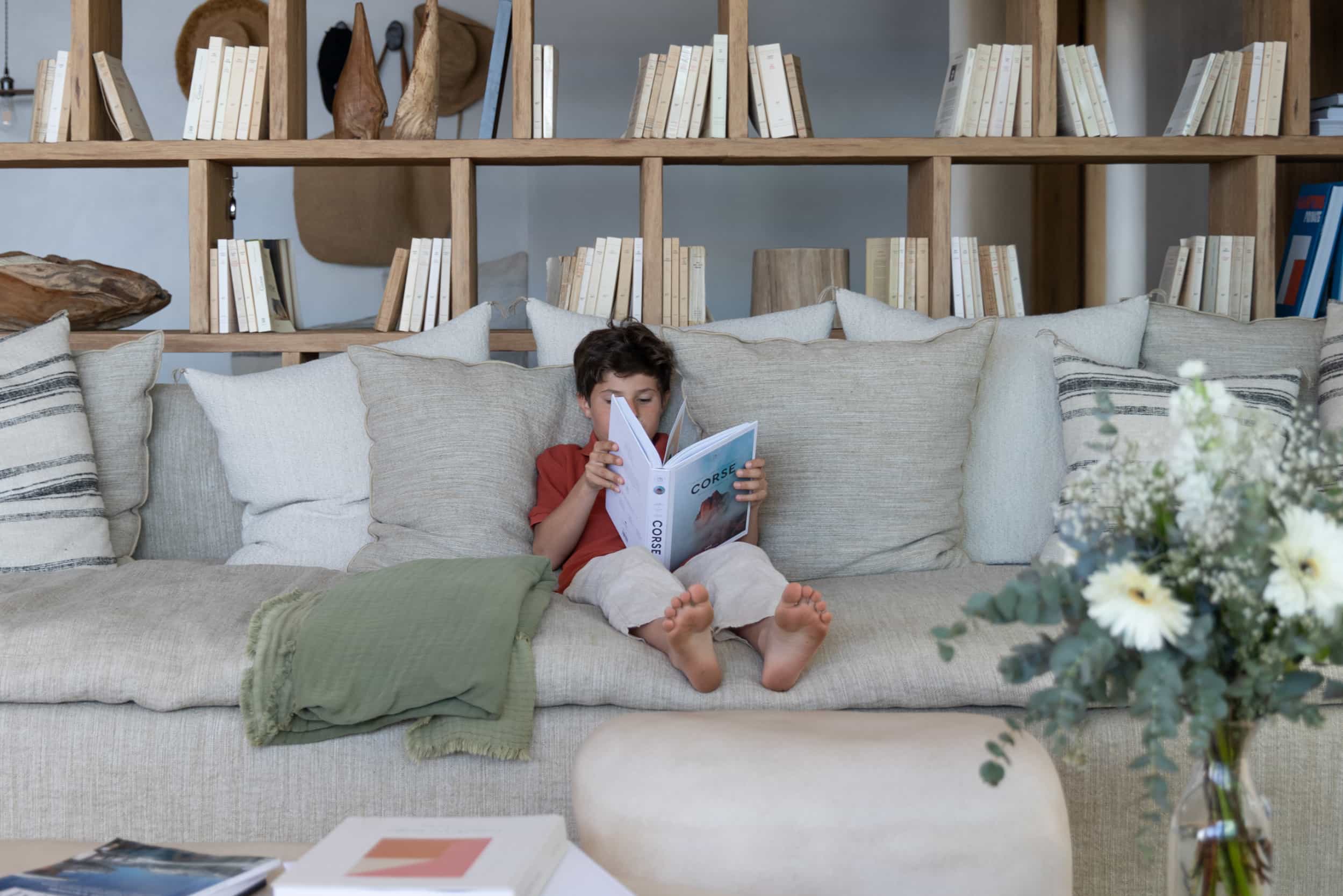 In-Corsica-in-winter-boy-sat-in-living-room-reading-book