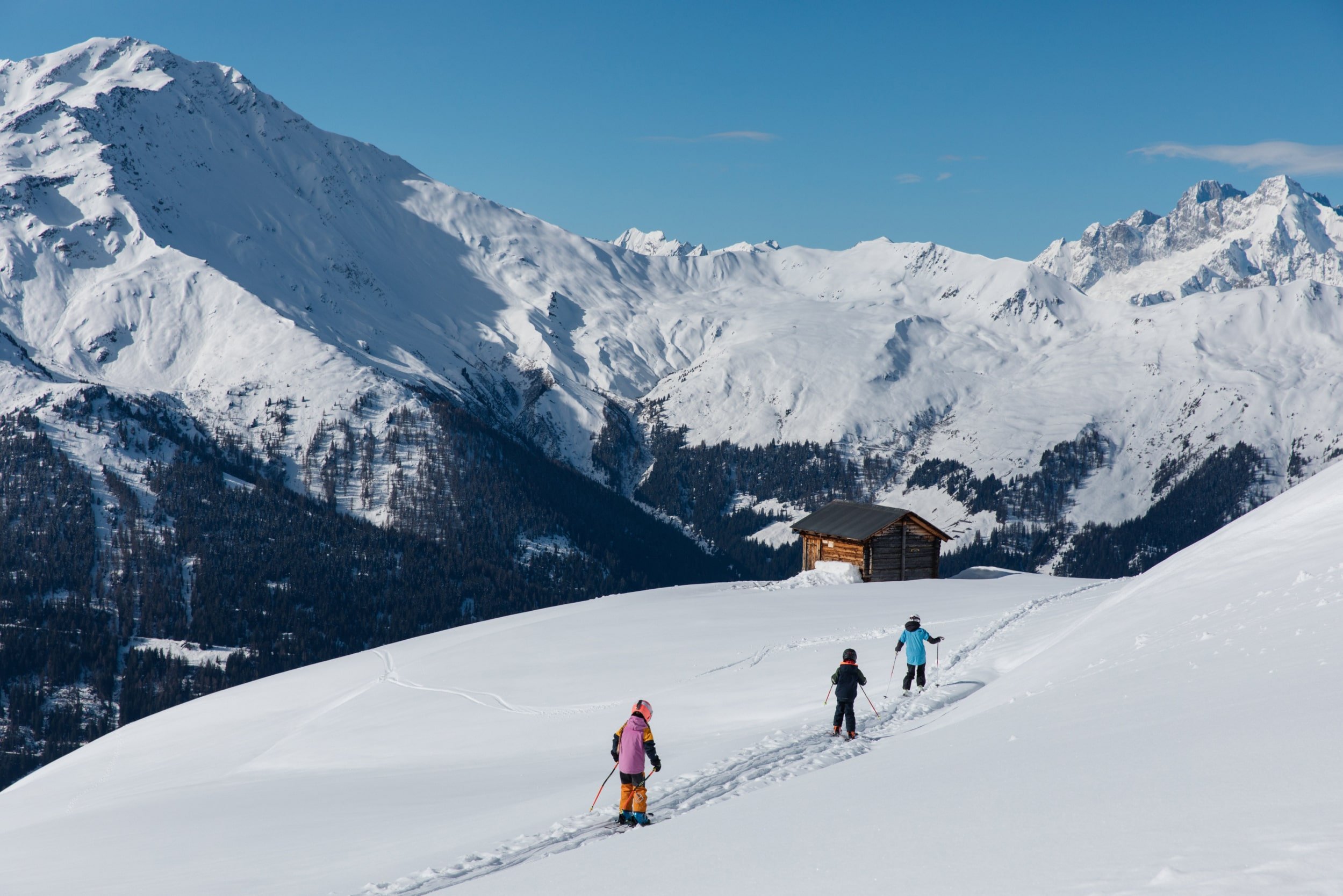 Skiing-in-Verbier-three-children-skiing-down-the-slopes