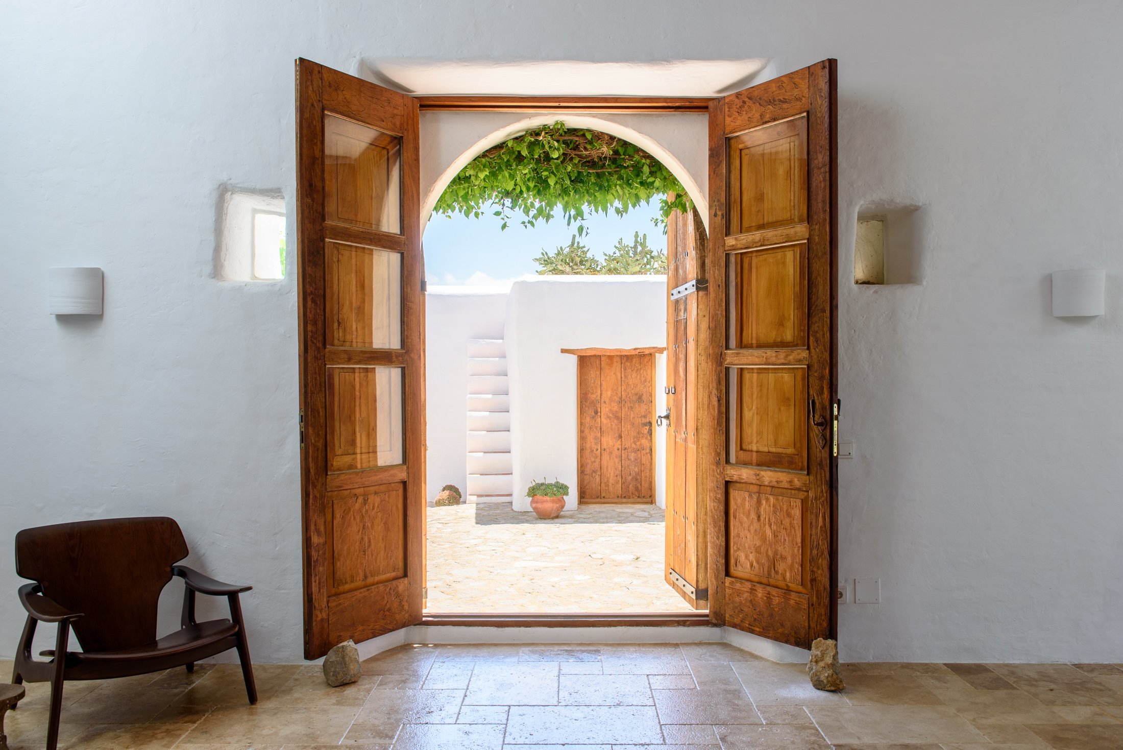 wooden double doors opening onto a courtyard in a Ibiza luxury villa
