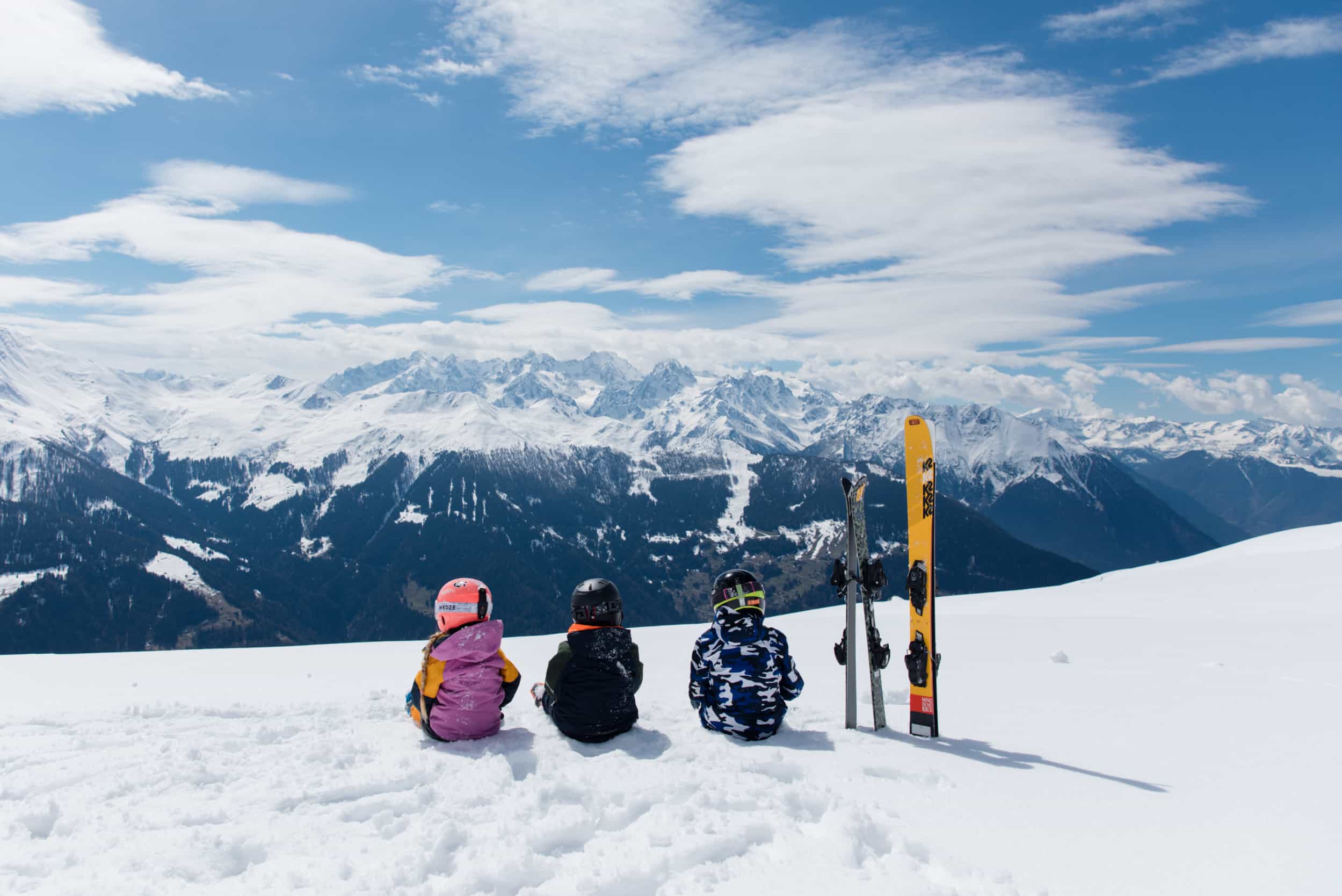 Three-children-sat-down-in-one-of-the-best-ski-stations-for-beginners