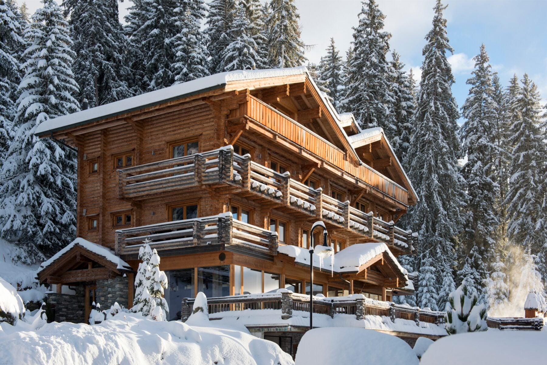 The Lodge, chalet de la Collection Iconic à Verbier, sous la neige au milieu des sapins