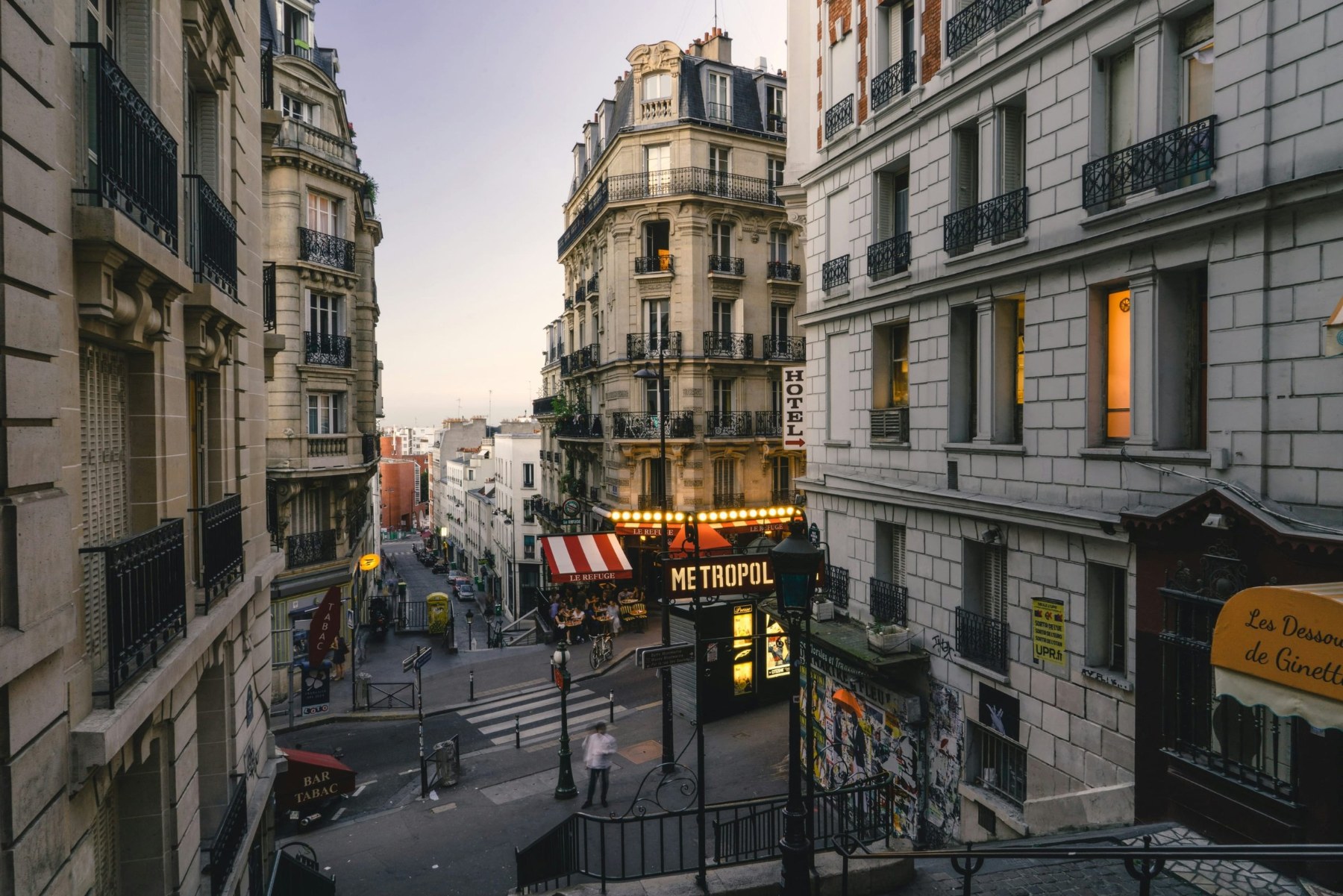 Haussmann buildings framing a Paris street at dusk