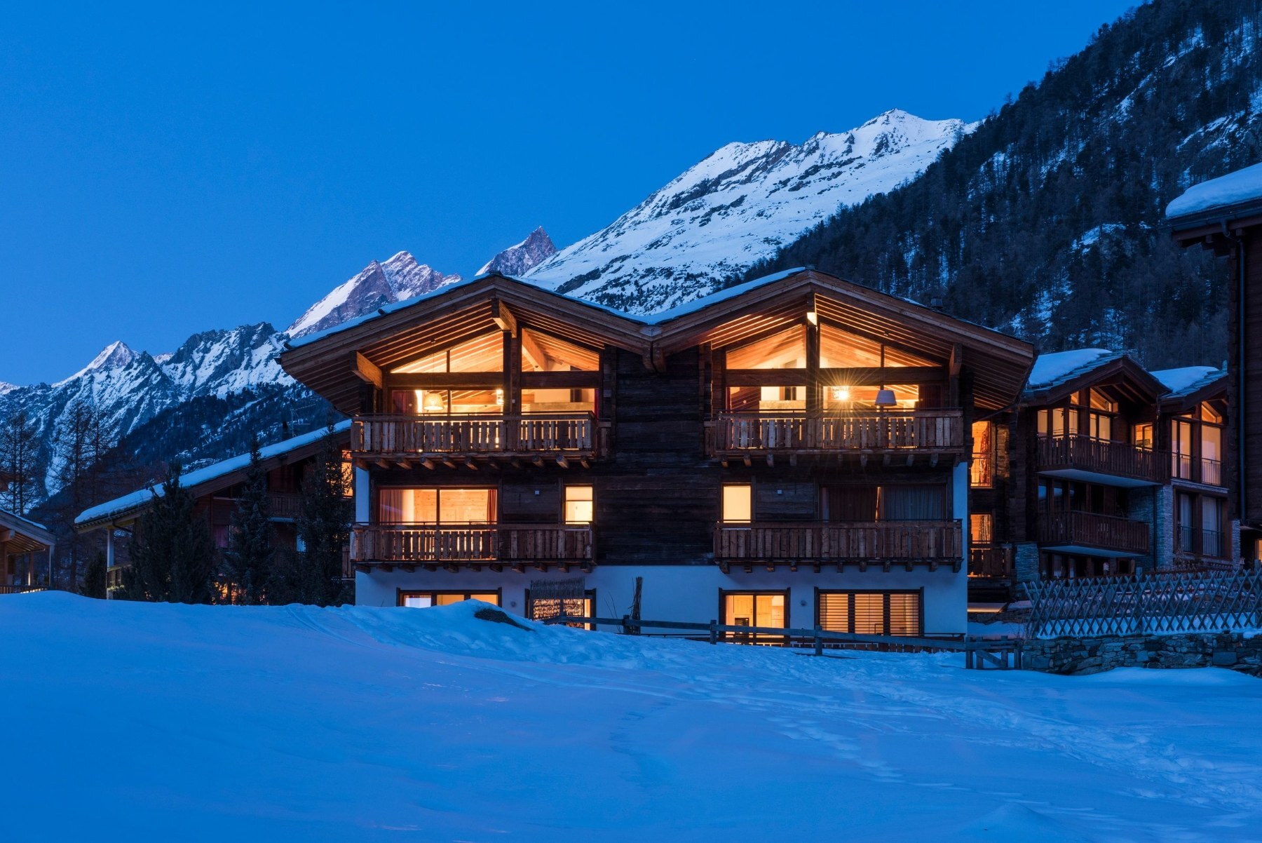 Le Chalet Shalimar illuminé au crépuscule, sous les sommets enneigés de Zermatt