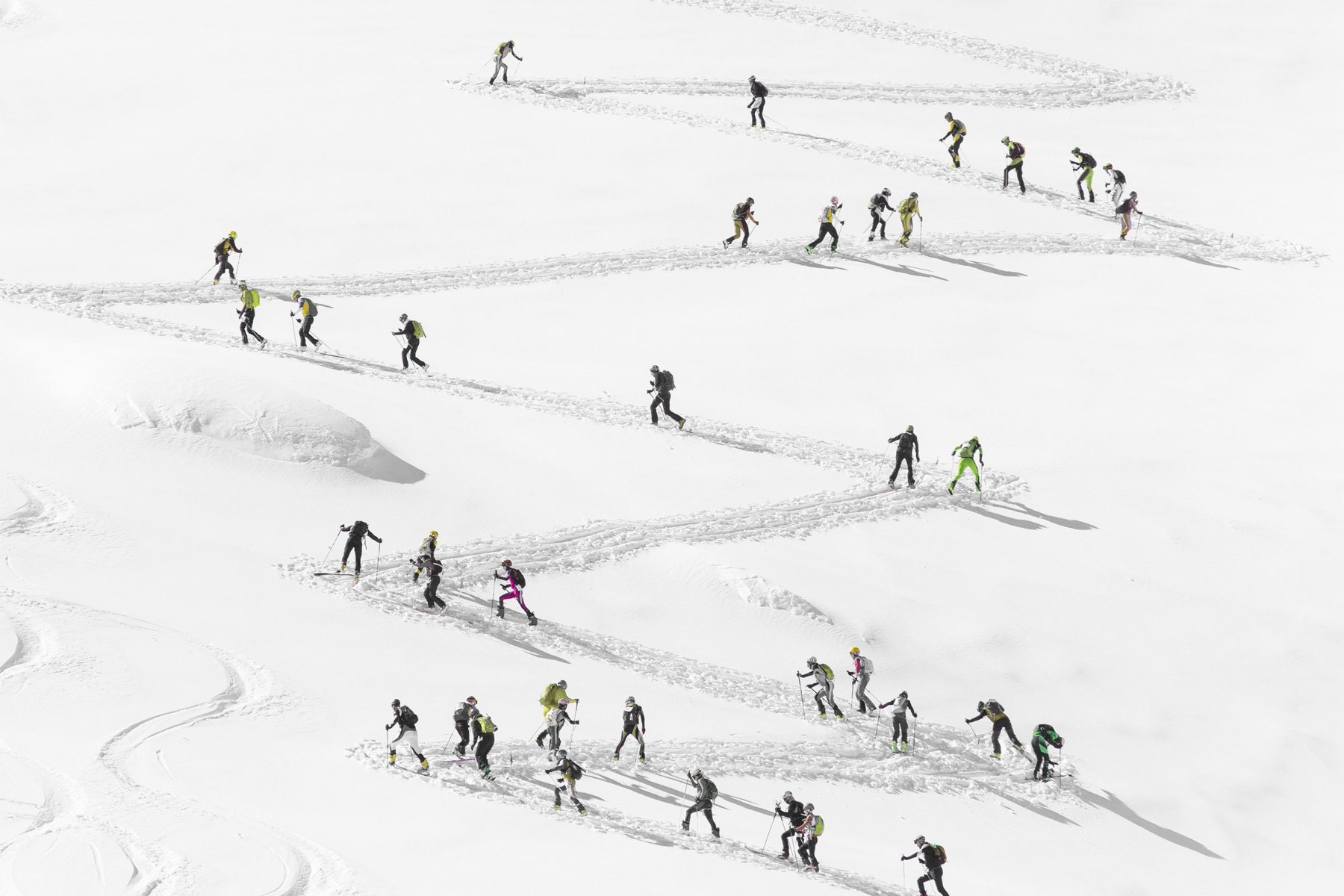 Des skieurs tracent leurs lignes dans la neige, vus du ciel
