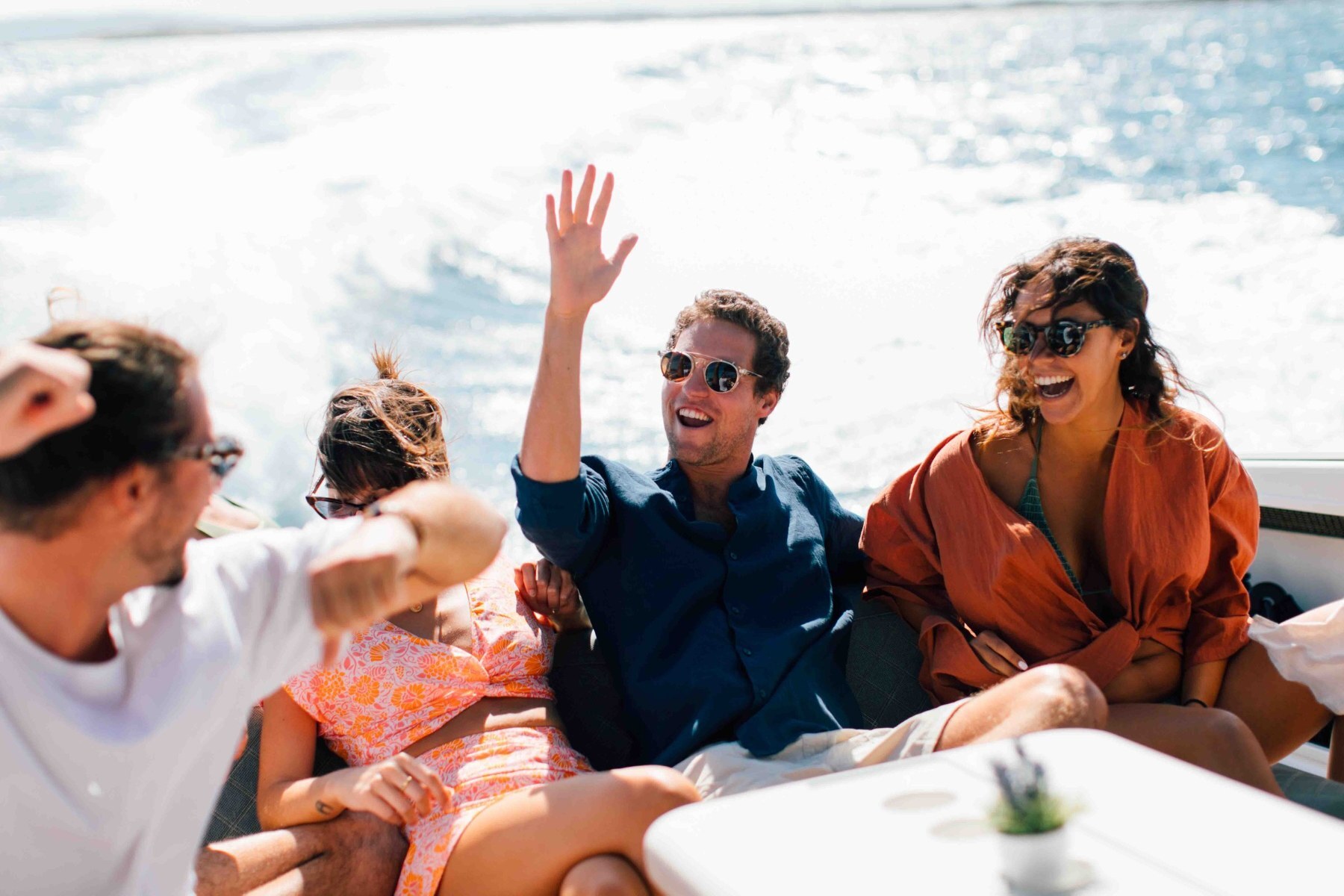 Un groupe d’amis rit à bord d’un bateau en pleine mer