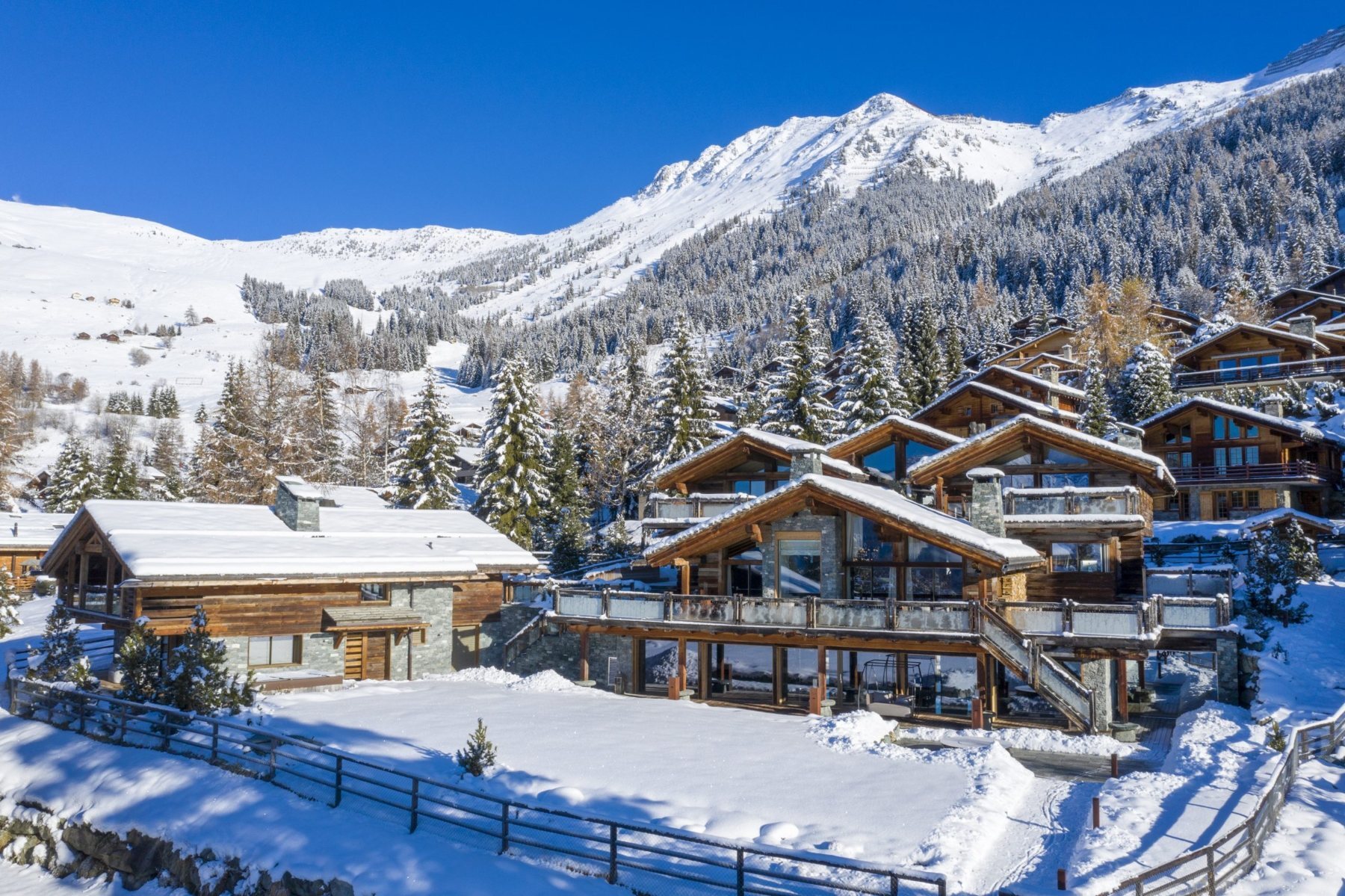 Chalet Marmottière among snow-covered chalets and pine trees in Verbier