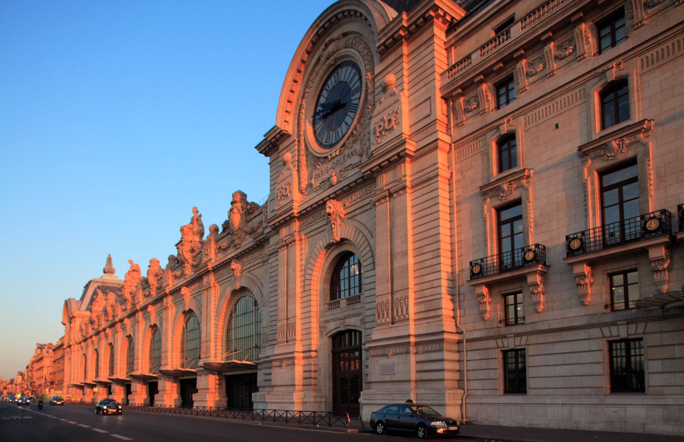 La façade du musée d’Orsay et son horloge dorée par le soleil couchant, à Paris